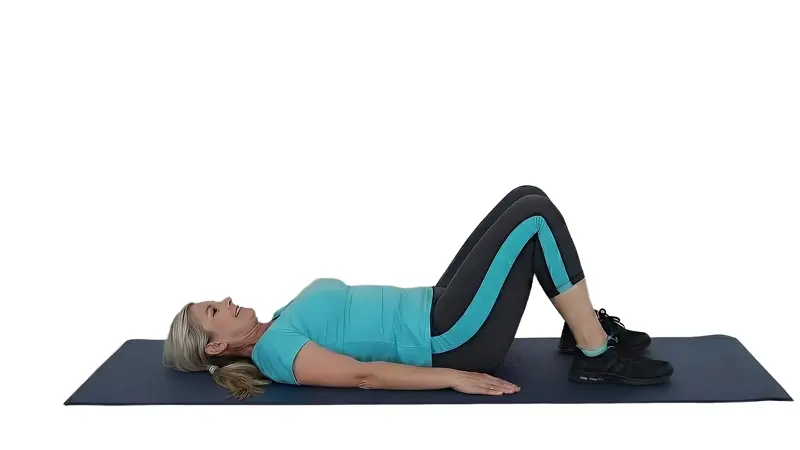 Woman performing a glute bridge exercise on her back to strengthen hip muscles and core.