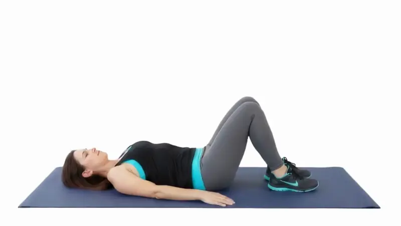 Person lying on their back performing a figure 4 stretch to improve hip mobility and glute flexibility.