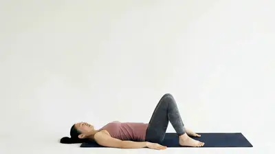 Looping video demonstration of the Glute Bridge exercise — a physician-designed movement performed on a mat in a bright studio.