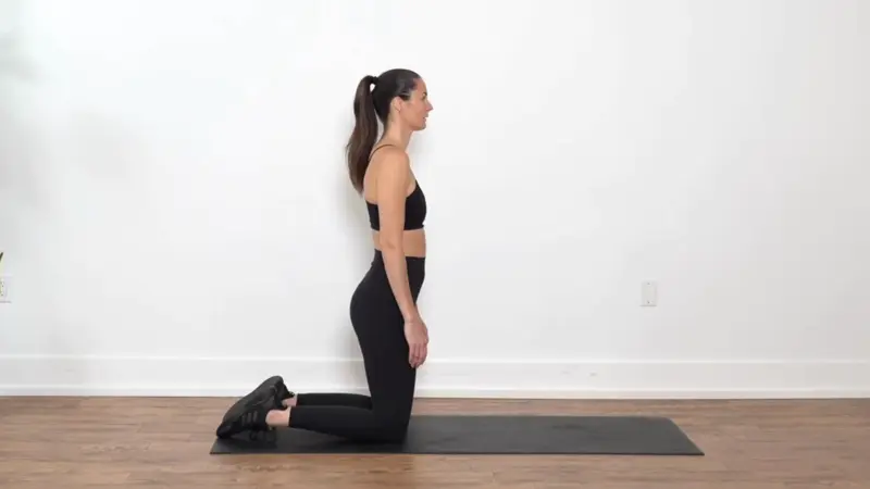 Person in a half-kneeling position stretching the hip flexors to reduce stiffness and improve mobility.