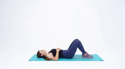 Looping video demonstration of the Supine Knee Side-to-Side exercise — a physician-designed movement performed on a mat in a bright studio.